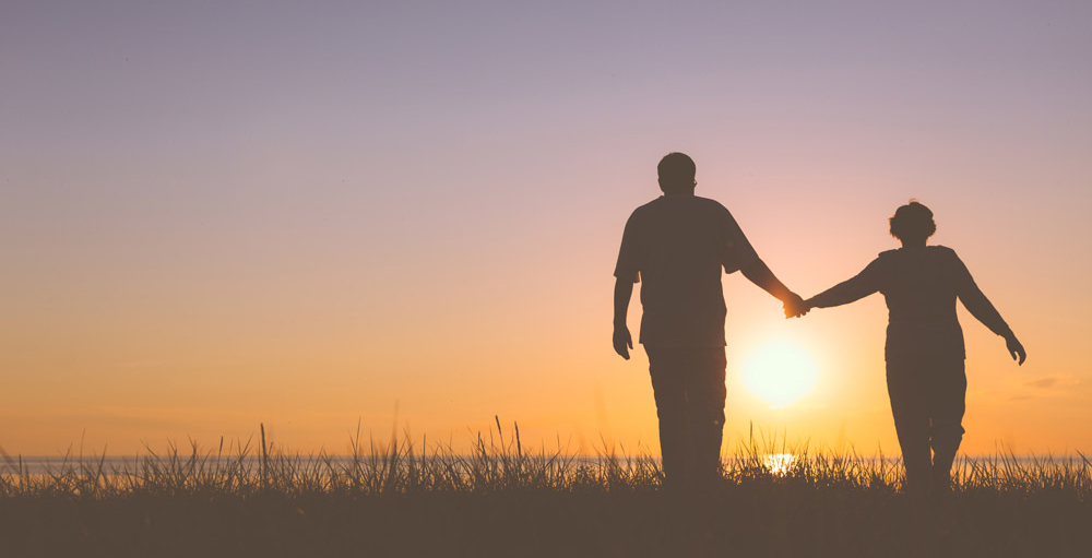 older-couple-walking-in-sunset